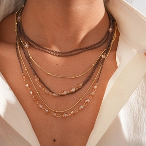 Close-up of layered necklace with champagne crystals and golden snake chains