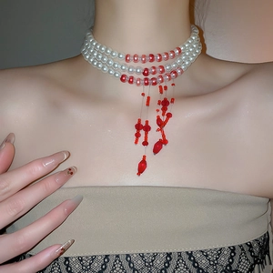 Close-up of elegant multi-layer pearl necklace with red bead tassels on model neck