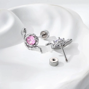 Boucles d'oreilles serpent en argent avec zircons roses et violets sur fond texturé