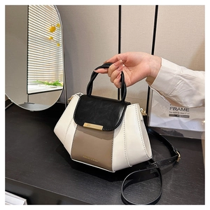 Close-up of contrast color handbag showing gold hardware and premium PU leather texture