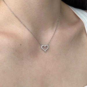 Close-up of S925 silver heart necklace with cubic zirconia pendant on neck
