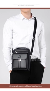 Detail of black crossbody bag featuring USB charging port and rhino logo texture
