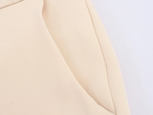 Macro shot of diagonal twill fabric texture and stitched side pocket on beige blazer suit