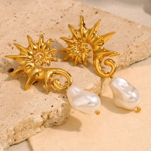 Boucles d'oreilles spirale dorées avec perles baroques sur socle de pierre