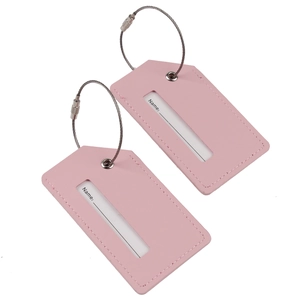 Detail view of two pink PU leather luggage tags with steel loops and name ID cards