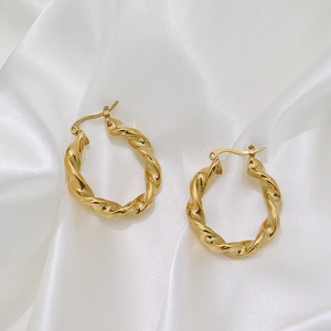 Élégantes boucles d'oreilles créoles torsadées en acier plaqué or 18 carats sur satin
