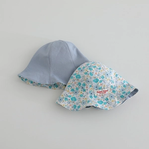 Détail d'un chapeau de soleil réversible pour bébé avec motif floral et tissu bleu clair