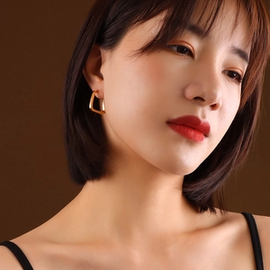 Minimalist U-shaped geometric square earrings in 18K gold plating worn by a female model