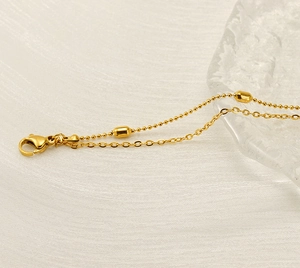 Detail of 18K gold plated double layer anklet with lobster clasp and bead chain