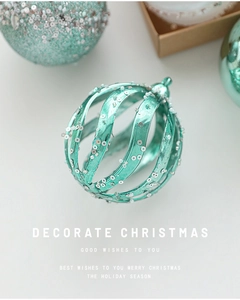 Macro view of mint green spiral Christmas ball ornament with silver sequins and glitter