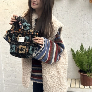 Detail of plush fleece handbag with colorful geometric patterns and Zakka woven label