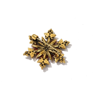 Golden snowflake Christmas brooch featuring a vintage metal back with detailed pin structure