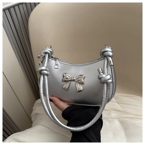 Detail of silver metallic crescent bag with large butterfly ornament and knotted handle