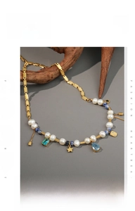 Detail of vintage necklace with freshwater pearls, blue beads and gold charms