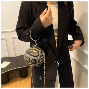 Detail of sequin leopard print spherical evening bag with gold ring handle and chain