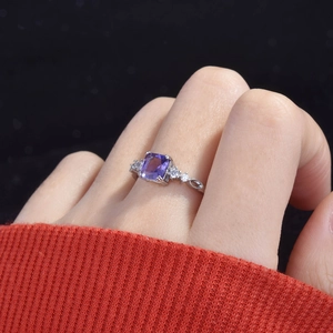 Detail of amethyst princess cut ring on finger with sparkling side diamonds