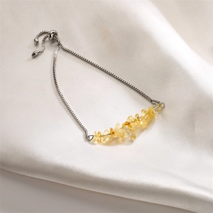 Detail view of adjustable silver chain bracelet with natural yellow crystal stones