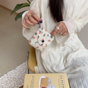 Close-up of floral bear pattern fabric mini storage bag with purple handle and button