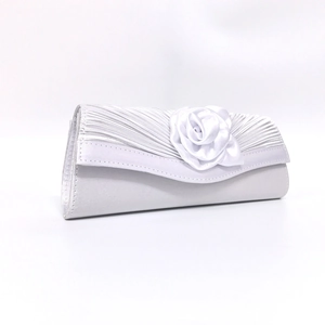 Detailed macro view of the elegant white satin evening clutch with handmade 3D floral accents