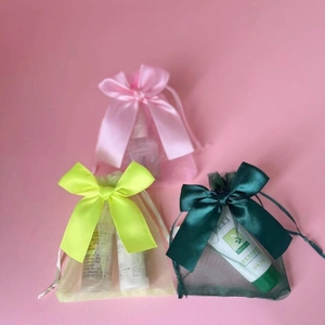 Three organza drawstring gift bags with silk ribbons in pink, lime and dark green colors
