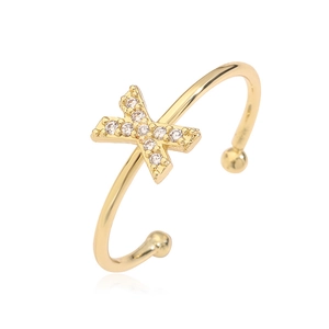 Macro shot of gold-plated open ring featuring a sparkling zircon-encrusted letter X detail