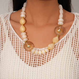 Detailed shot of irregular acrylic beads necklace with gold metal spacers worn on model