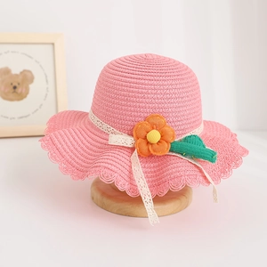 Close-up of pink straw hat with yellow flower, cactus charm and lace ribbon detail