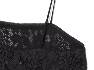 Detail of black lace camisole showing adjustable thin straps and delicate mesh texture