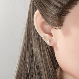 Classic 18K gold clover earrings with clear zircon stones on a female model