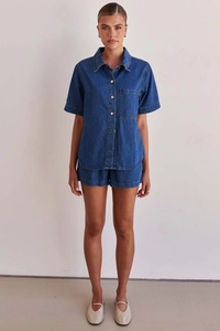 Detail shot of blue denim shirt and shorts set with stitching and pocket design