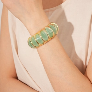 Close-up of vintage stretch bracelet with light green resin and gold metal edges