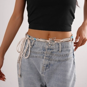 Detail of bohemian waist chain with silver butterfly pendants and blue beads on denim