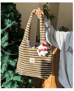 Detail of plush tote bag with brown stripes and cute cartoon dog holiday charm