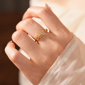 Détail d'une bague vintage dorée avec zircons en forme d'étoile portée à la main