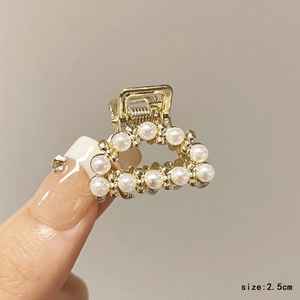 Detail view of 2.5cm gold rhinestone hair claw clip with pearls for girls