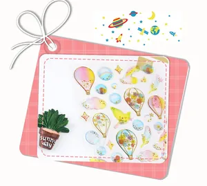 Detail of transparent sticker sheet with gold foil hot air balloons and clouds