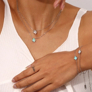 Detailed shot of stainless steel double layer opal teardrop necklace and bracelet.