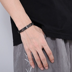 Gros plan d'un bracelet gourmette en acier inoxydable noir mat pour homme au poignet
