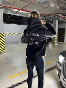 Sweat à capuche oversize noir avec grand imprimé blanc au dos en garage souterrain