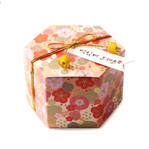Caja de regalo hexagonal para dulces con flores de ciruelo y cordón dorado festivo