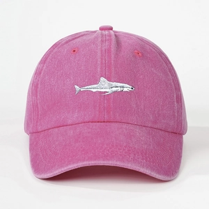 Detailed close-up of white shark embroidery on pink washed cotton baseball cap