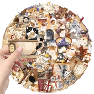 Close-up of hand holding a cartoon cat coffee sticker from a transparent PET sticker set