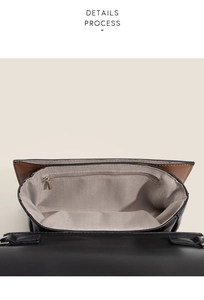 Detail view of the handbag interior with grey herringbone lining and metal zipper pocket