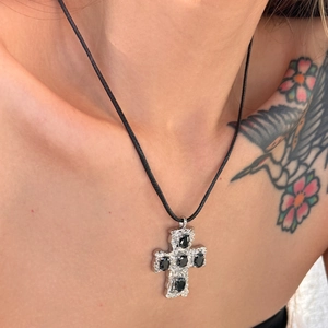 Detail of 18k gold plated titanium steel cross pendant on black cord necklace for women