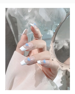 Detail of French style press-on nails with blue hearts and small pearl decorations