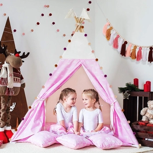 Detail of pink and white crown pattern play tent with wooden poles and pompom garland