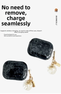 Close-up of black marble case for AirPods Pro with elegant pearl and gold keychain