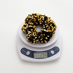 Elastic gold sequin hair scrunchie shown on a scale weighing 17.4g for high-quality accessory