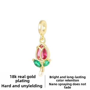 Detailed macro view of 18k gold plated rose pendant with pink crystal and green leaves