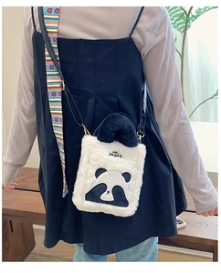 Detail showing the white panda plush crossbody bag with black ears and logo lettering